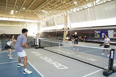 Four players on an indoor pickleball court engaged in a doubles game powered by fairplay pickleball app
